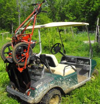 Mower on the back of the golf cart.