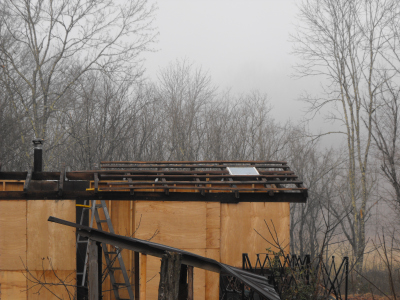 Storage building with first roof rafters on