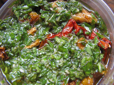 Layering basil, oil, garlic, and tomatoes