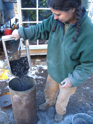 Pouring charcoal into a metal bin for storage