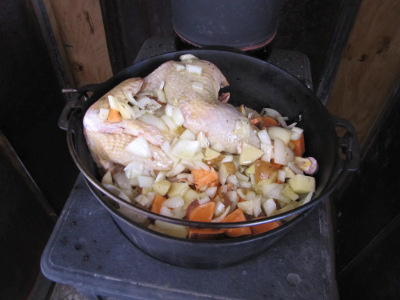 Cooking a chicken in a Dutch oven on a wood stove