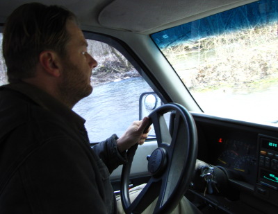 truck driver close up crossing creek on cold day