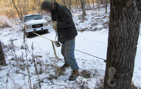 hand winching a truck up a hill on a cold snowy day