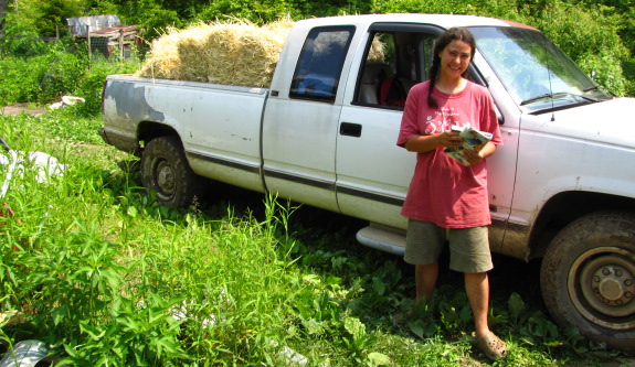 straw mulch in a truck with Anna in front