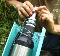 pump being secured to a large piece of PVC pipe cut down the middle