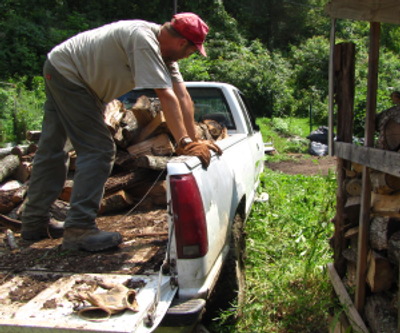 me in back of pick up truck of fire wood being off loaded