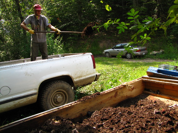 Shoveling manure into the worm bin