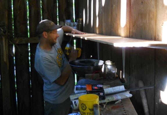 using Dewalt impact drill to secure shelf to barn wall