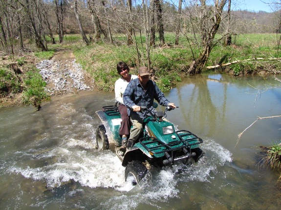 using ATV to ferry passengers across the creek