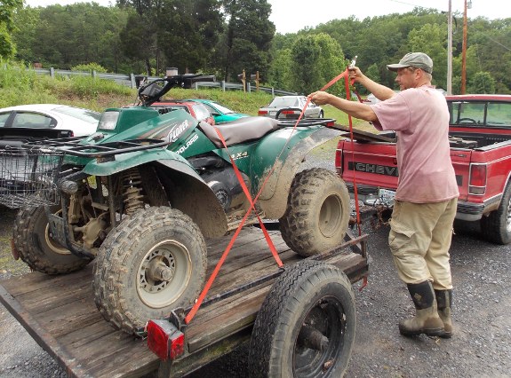 ATV on trailer being tied down with ratchet straps