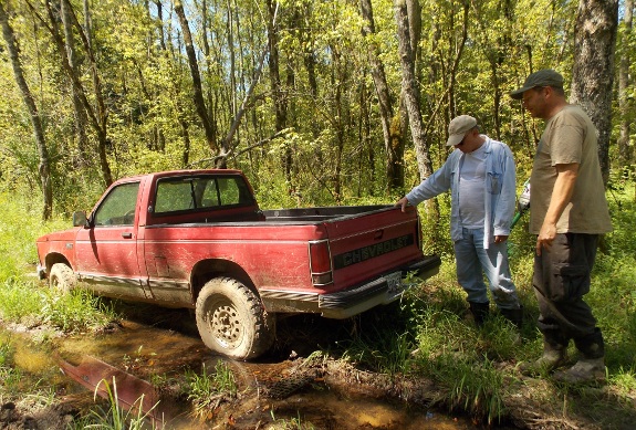 Chevy S-10 truck stuck in the mud with me and Frankie looking at it