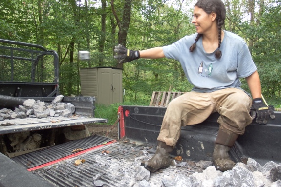 Anna throwing rocks from the truck to the Kubota.