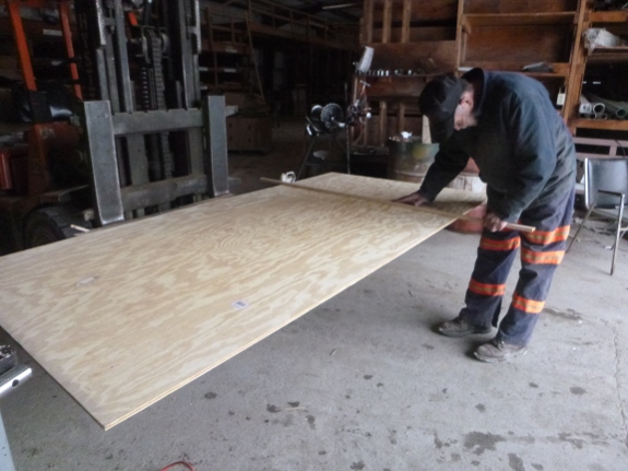 Cutting plywood with a fork lift.
